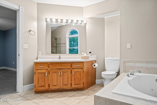 bathroom with vanity, tiled bath, tile patterned flooring, and toilet