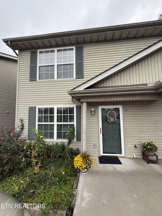 view of exterior entry with a patio