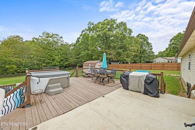 wooden deck featuring a hot tub, a shed, and grilling area