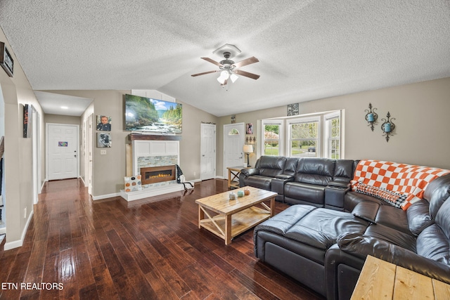 living room with ceiling fan, a textured ceiling, lofted ceiling, and dark hardwood / wood-style floors