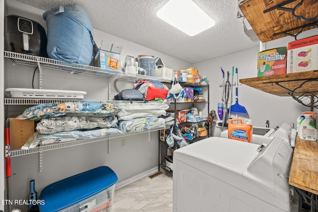 laundry room featuring a textured ceiling and independent washer and dryer