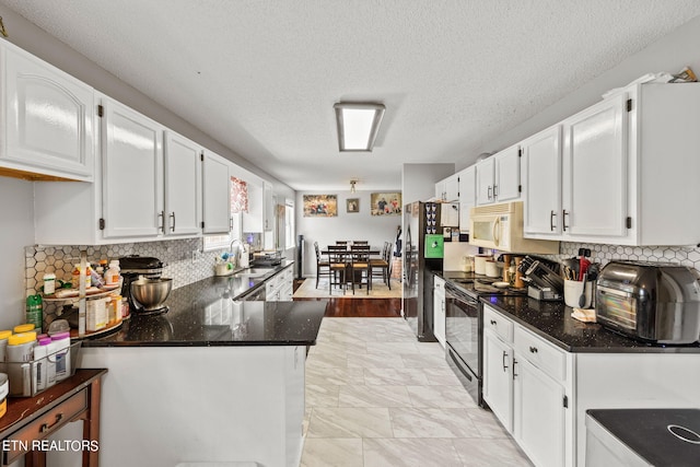 kitchen featuring dark stone counters, a textured ceiling, white cabinetry, kitchen peninsula, and black / electric stove