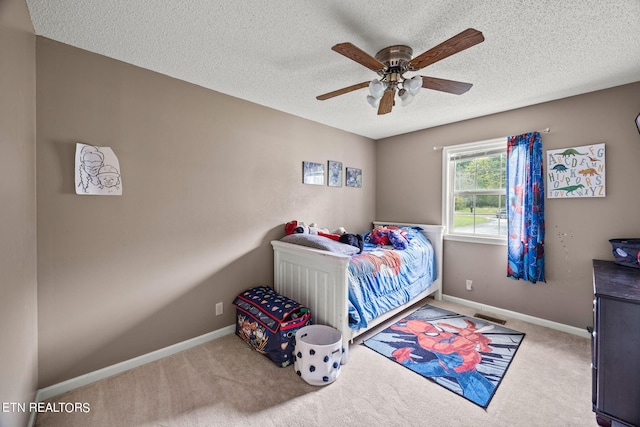 bedroom with ceiling fan, a textured ceiling, and carpet