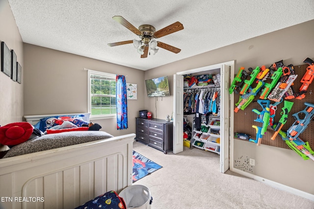 carpeted bedroom featuring a textured ceiling, ceiling fan, and a closet