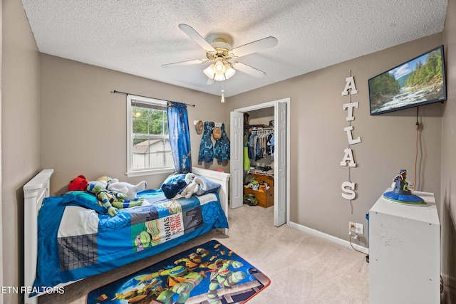 carpeted bedroom with a closet, ceiling fan, and a textured ceiling