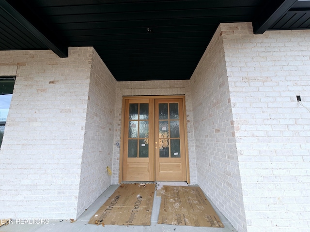 view of exterior entry with french doors and brick siding