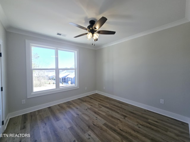 empty room featuring visible vents, baseboards, dark wood-style floors, and ornamental molding