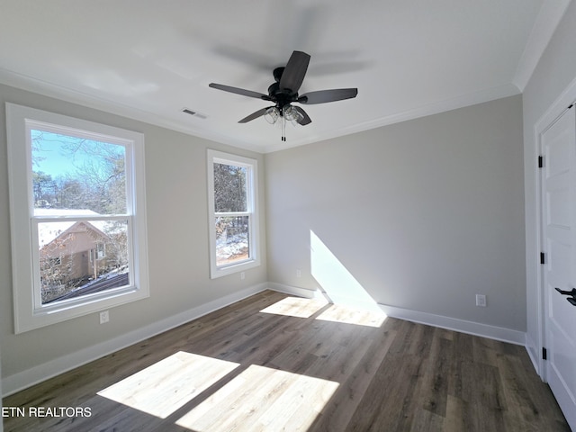 spare room featuring visible vents, baseboards, dark wood finished floors, ceiling fan, and ornamental molding