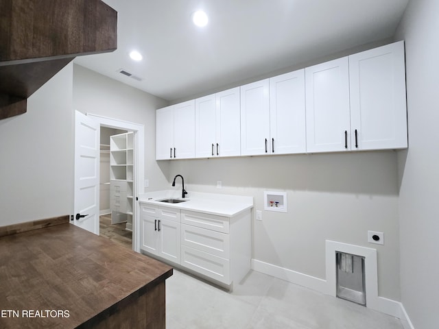 clothes washing area with visible vents, a sink, cabinet space, hookup for an electric dryer, and hookup for a washing machine