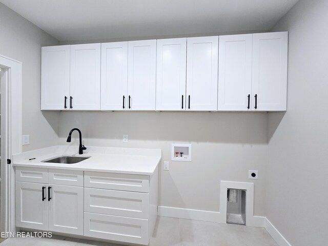 laundry room featuring electric dryer hookup, washer hookup, a sink, cabinet space, and baseboards