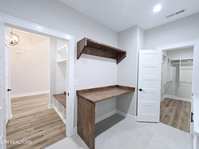 mudroom featuring light wood finished floors, visible vents, a notable chandelier, and baseboards