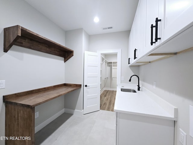 clothes washing area with a sink, visible vents, baseboards, and recessed lighting