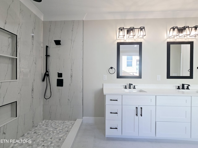 full bathroom with a sink, a marble finish shower, baseboards, and double vanity