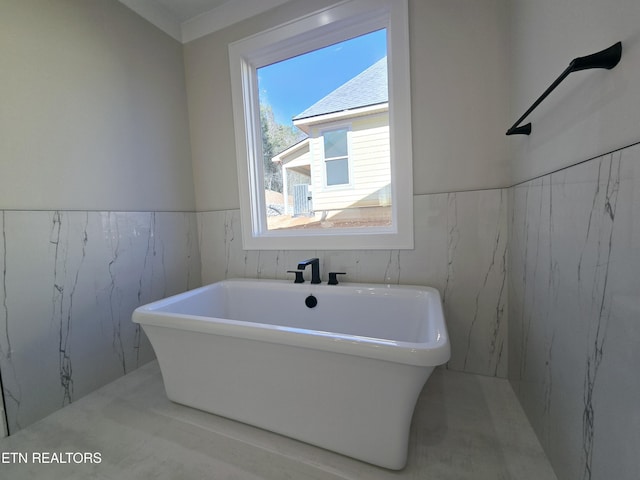 bathroom with a soaking tub and wainscoting