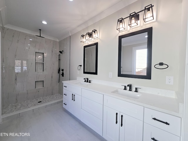 full bath featuring a marble finish shower, double vanity, crown molding, and a sink