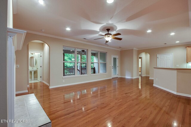 unfurnished living room with ornamental molding, ceiling fan, and light hardwood / wood-style flooring