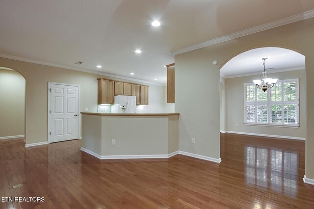 kitchen featuring light brown cabinetry, white refrigerator with ice dispenser, an inviting chandelier, light wood-type flooring, and crown molding