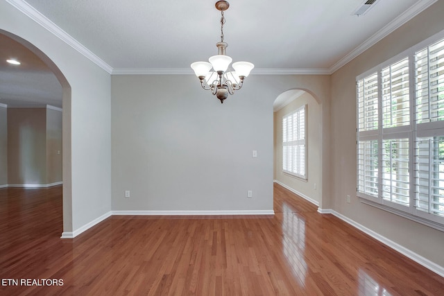 unfurnished room featuring an inviting chandelier, ornamental molding, and hardwood / wood-style floors