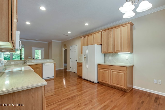 kitchen with sink, ornamental molding, white appliances, light hardwood / wood-style flooring, and an inviting chandelier