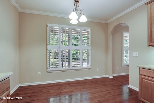 unfurnished dining area featuring crown molding, dark hardwood / wood-style floors, and a chandelier