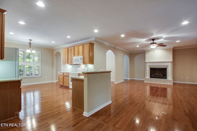 kitchen with light hardwood / wood-style floors, white appliances, and light brown cabinets