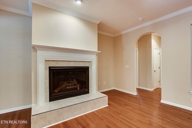 unfurnished living room with ornamental molding, wood-type flooring, and a fireplace