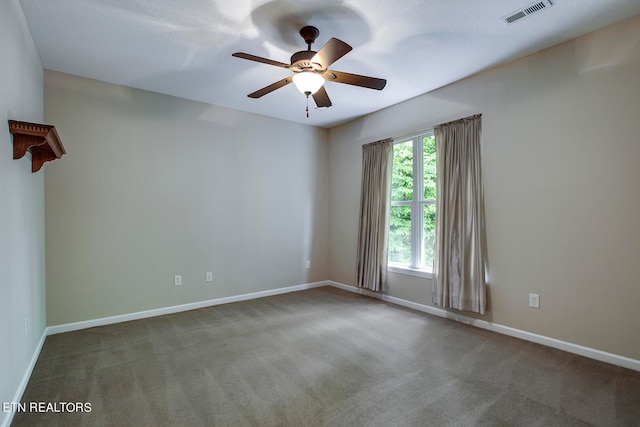 carpeted spare room featuring ceiling fan