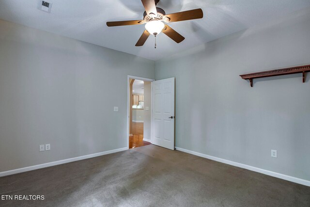 unfurnished room featuring dark colored carpet and ceiling fan