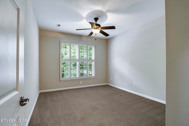 empty room featuring a textured ceiling, ceiling fan, and dark carpet