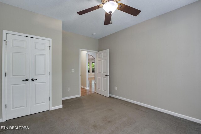 unfurnished bedroom featuring ceiling fan, light colored carpet, and a closet