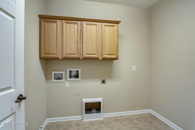 clothes washing area with washer hookup, electric dryer hookup, cabinets, and light tile patterned floors