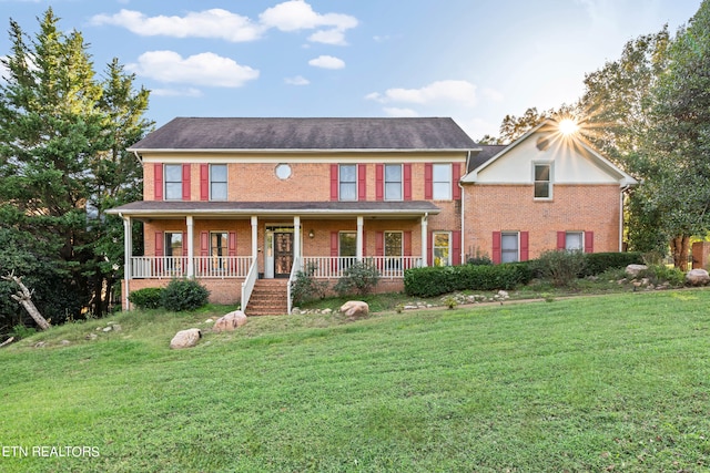 colonial-style house featuring a front lawn and covered porch