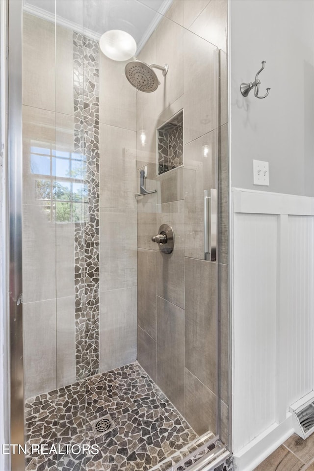 bathroom featuring crown molding, hardwood / wood-style floors, and an enclosed shower