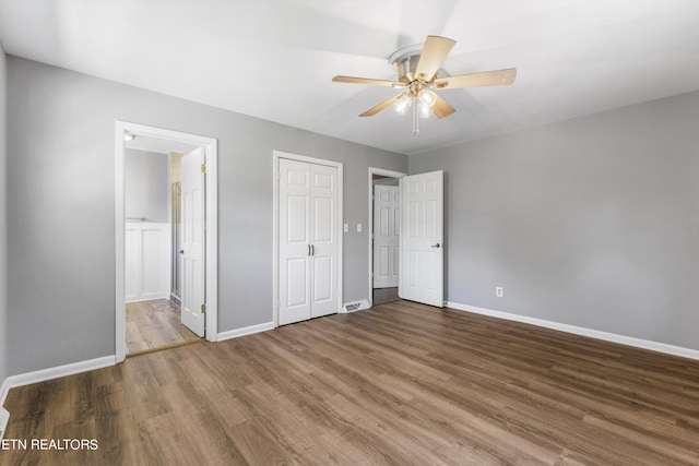 unfurnished bedroom with ceiling fan, hardwood / wood-style flooring, and ensuite bathroom