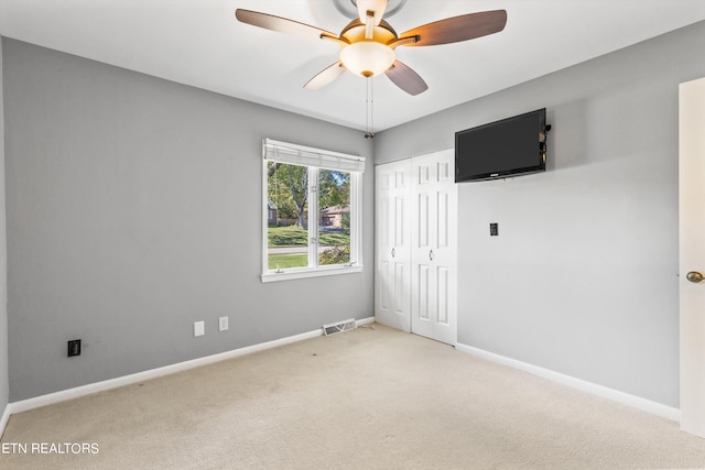 carpeted empty room with ceiling fan