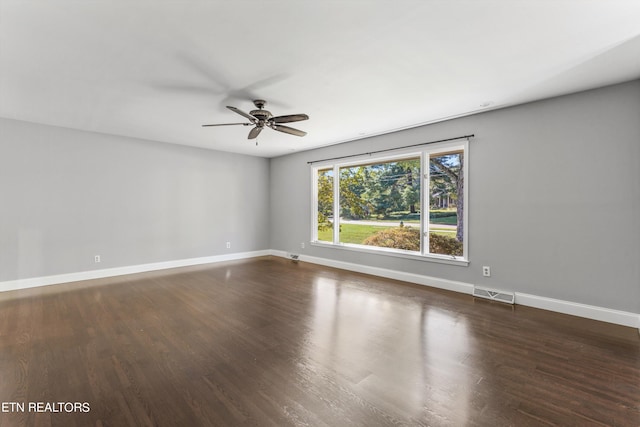 spare room featuring ceiling fan and dark wood-type flooring