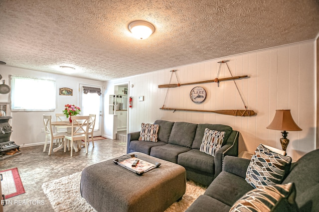 living room with wood walls and a textured ceiling