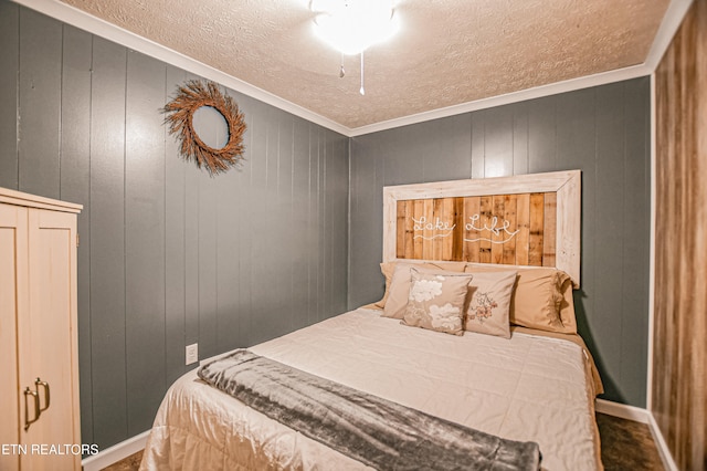 bedroom featuring ornamental molding, wood walls, and a textured ceiling