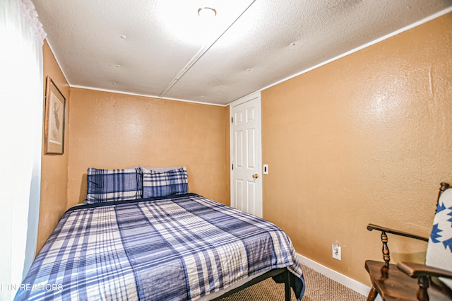 bedroom featuring a textured ceiling and carpet