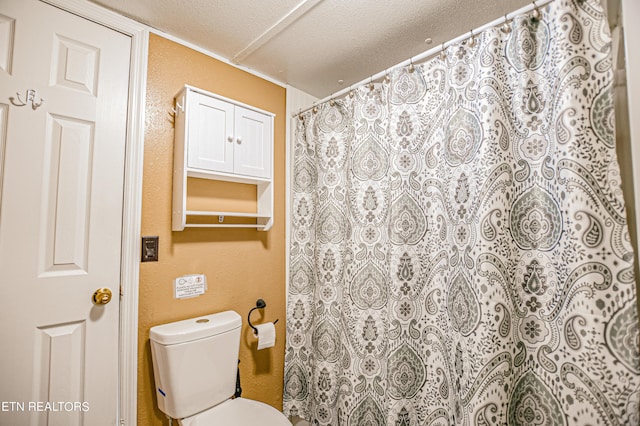 bathroom featuring a textured ceiling, curtained shower, and toilet