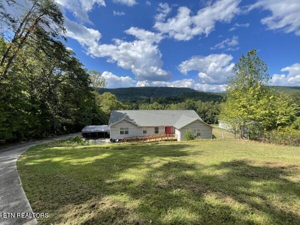 view of front of property with a deck and a front yard