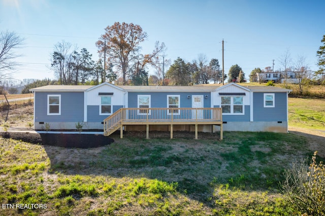 rear view of property with a lawn and a deck