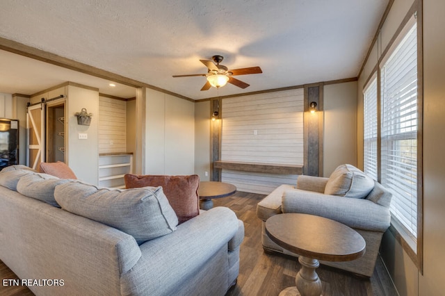 living room with hardwood / wood-style flooring, ceiling fan, plenty of natural light, and a barn door