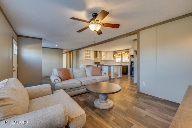 living room featuring sink, hardwood / wood-style flooring, ornamental molding, and ceiling fan