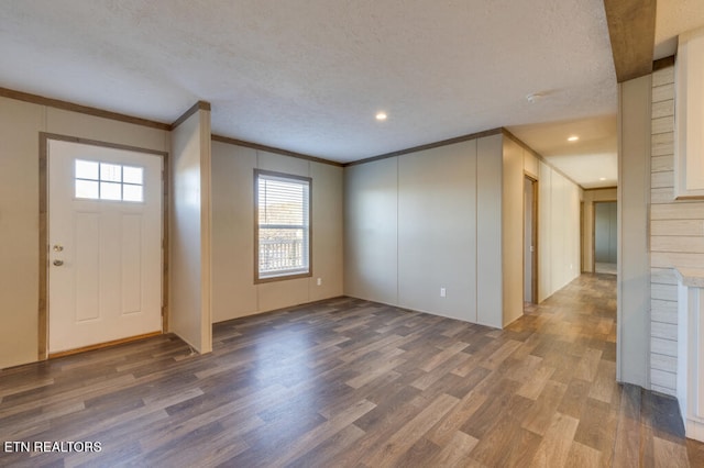 foyer featuring crown molding, wood-type flooring, and a textured ceiling