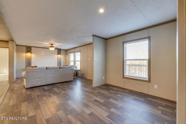 unfurnished living room with crown molding, a textured ceiling, and dark hardwood / wood-style flooring