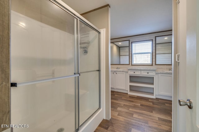 bathroom with an enclosed shower, wood-type flooring, and vanity