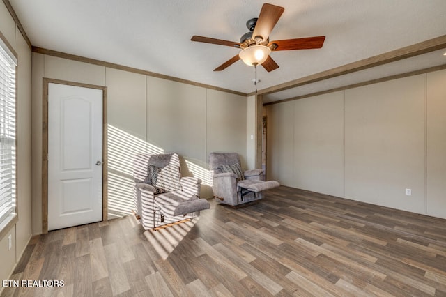 sitting room featuring crown molding, a healthy amount of sunlight, and hardwood / wood-style floors