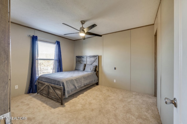 bedroom with ceiling fan, light colored carpet, and a textured ceiling