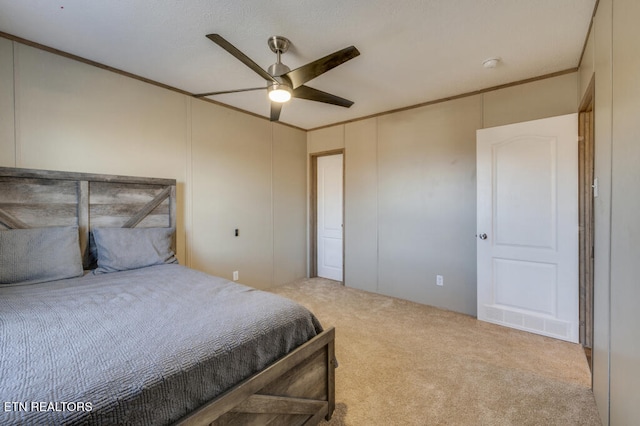 carpeted bedroom featuring ornamental molding and ceiling fan